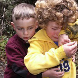young boy consoling another child who is crying