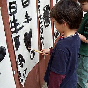 child painting some chinese characters and other figures